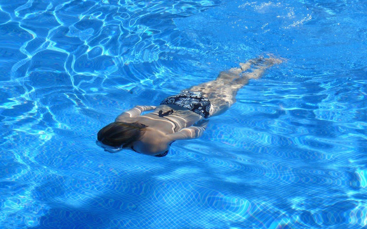 Eine Frau schwimmt im Pool.